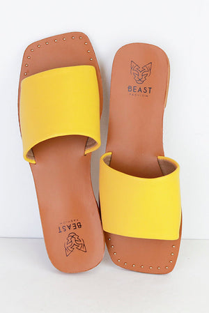 Bright yellow JOEY-01 Minimalist Slide Sandals by Beast Fashion, perfect for summer vacations. These stylish flats feature a sleek design and a single wide strap, making them ideal for casual outings. Great choice among sandals on sale for your summer adventures.